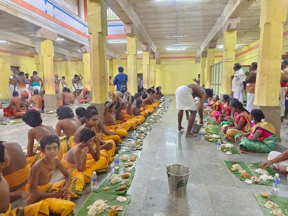 Children and devotees eating on banana leaves at bhandara