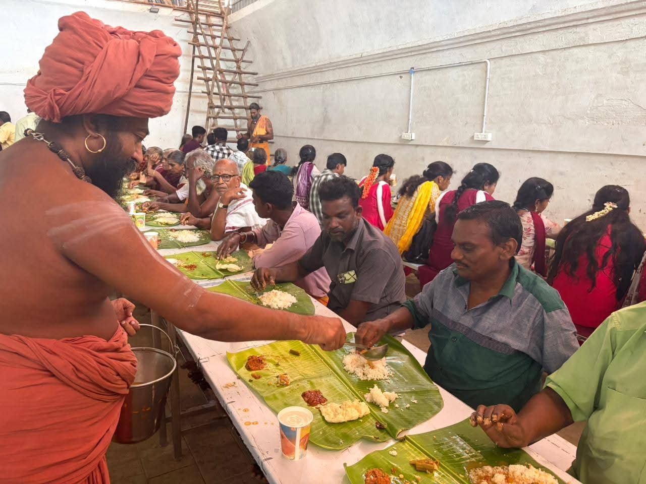 Saint serving food to devotees at bhandara